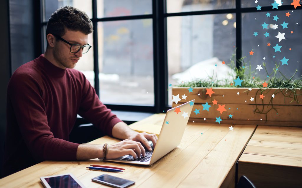 photo of a man with glasses typing on a laptop