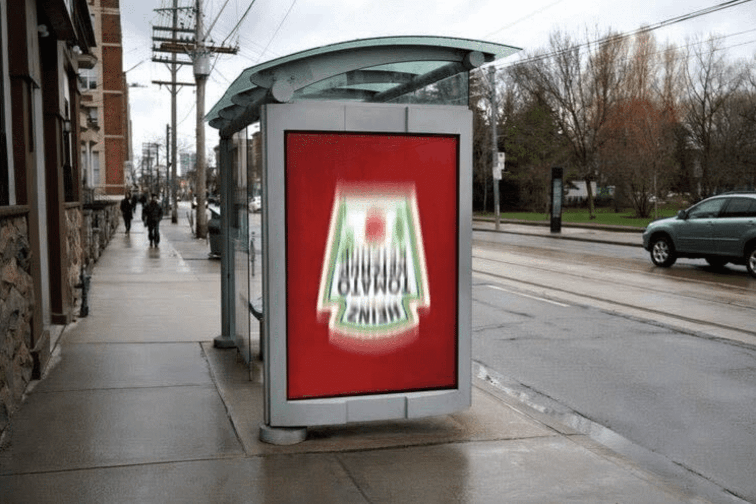 photo of a Heinz bus bench ad that's entirely red with their logo upside down and blurred as if being shaken like a bottle of ketchup